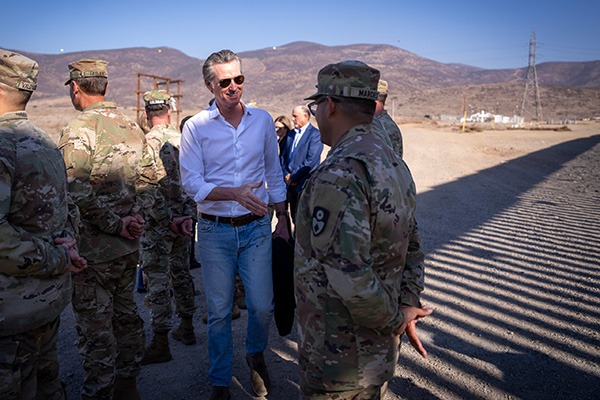 Gavin Newsom shaking hands with guard